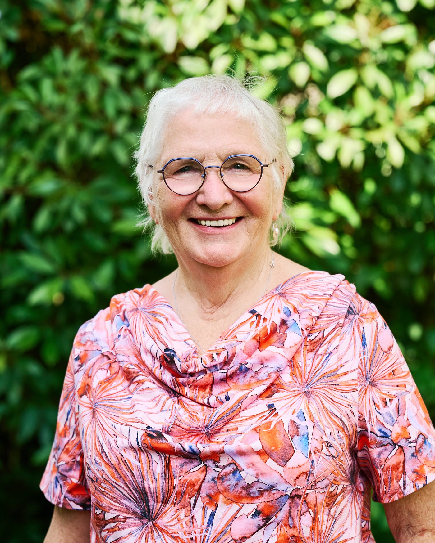 Porträt von Eva Ursula Pellio vor einem Rhododendron